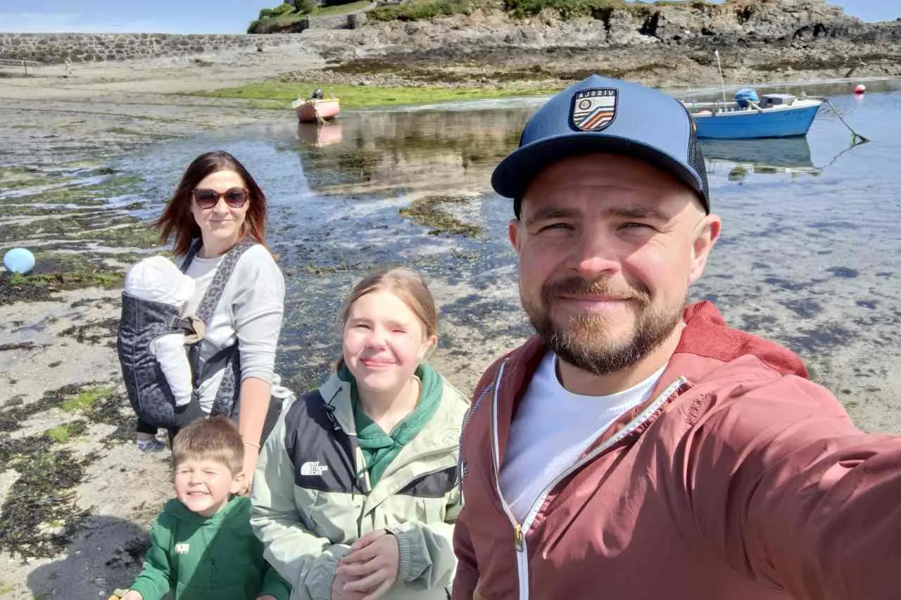 The family behind Terra Sauna enjoying a sunny day on a Guernsey beach, representing our local roots and passion for wellness.
