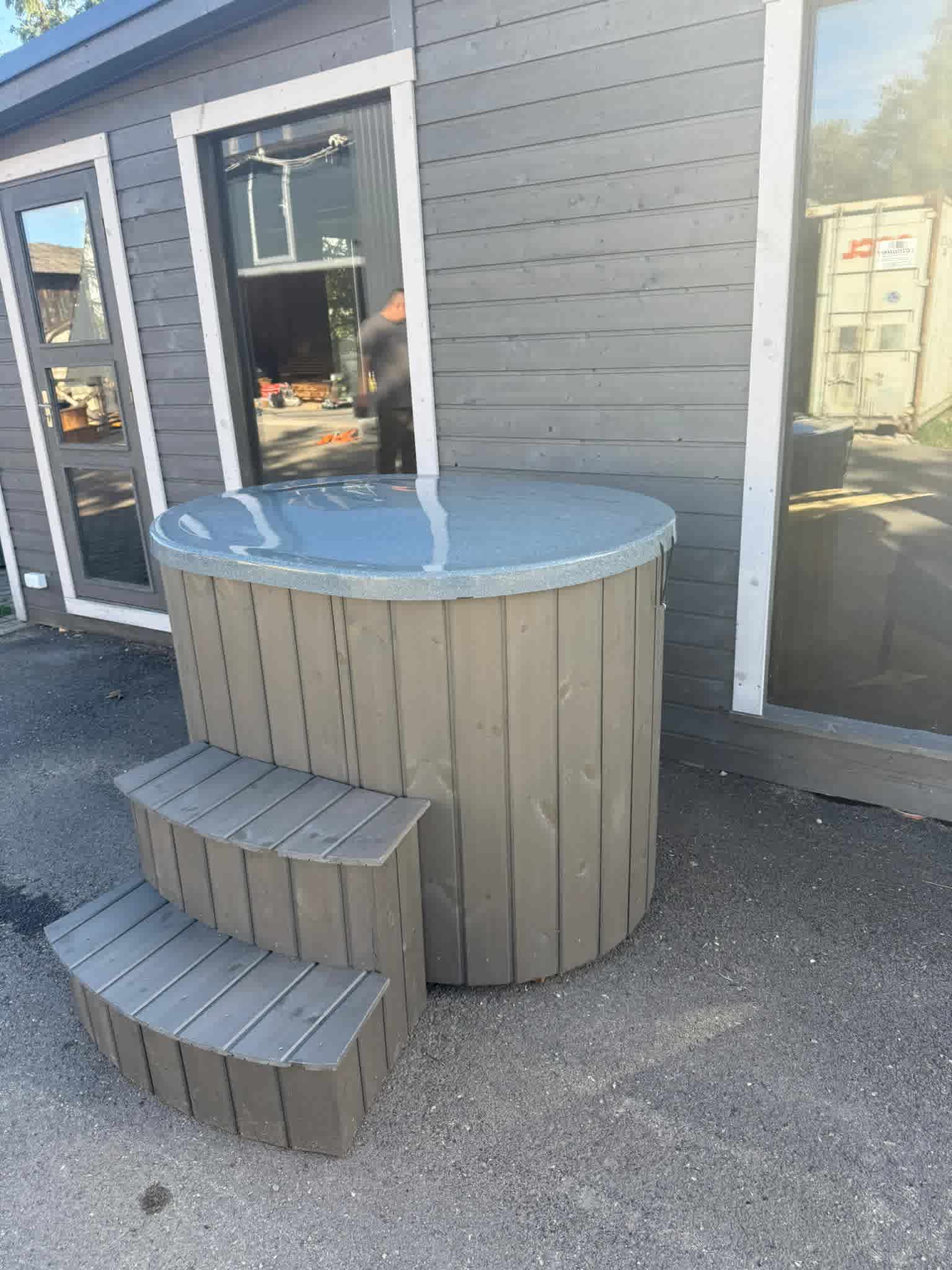 The Labrum: A premium one-person cold plunge tub with Pearlescent Blue interior, grey spruce cladding, matching steps, and a fiberglass lid.