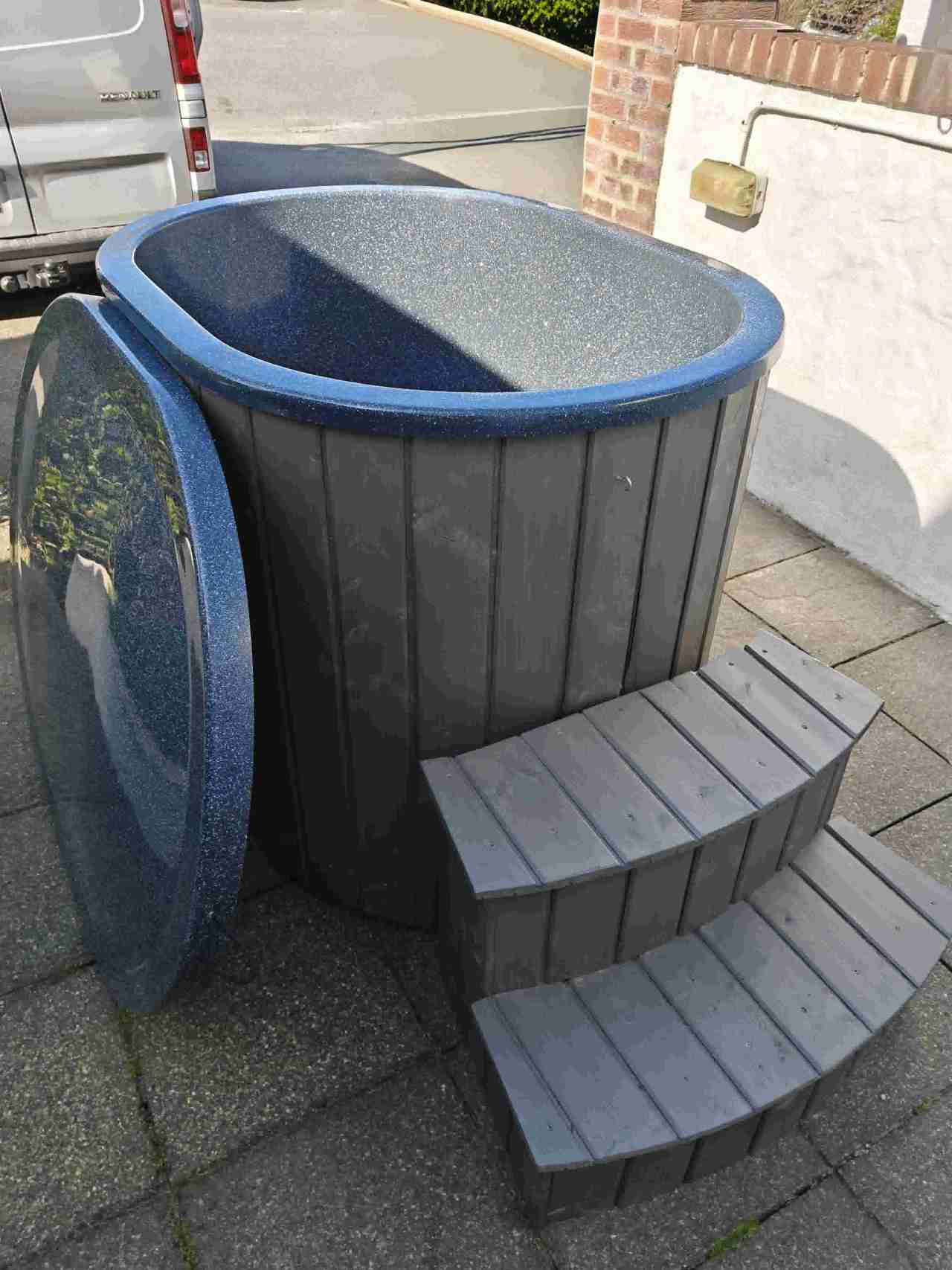 The Labrum single-person cold plunge tub with shimmering Pearlescent Blue liner, grey spruce cladding, and matching fiberglass lid.